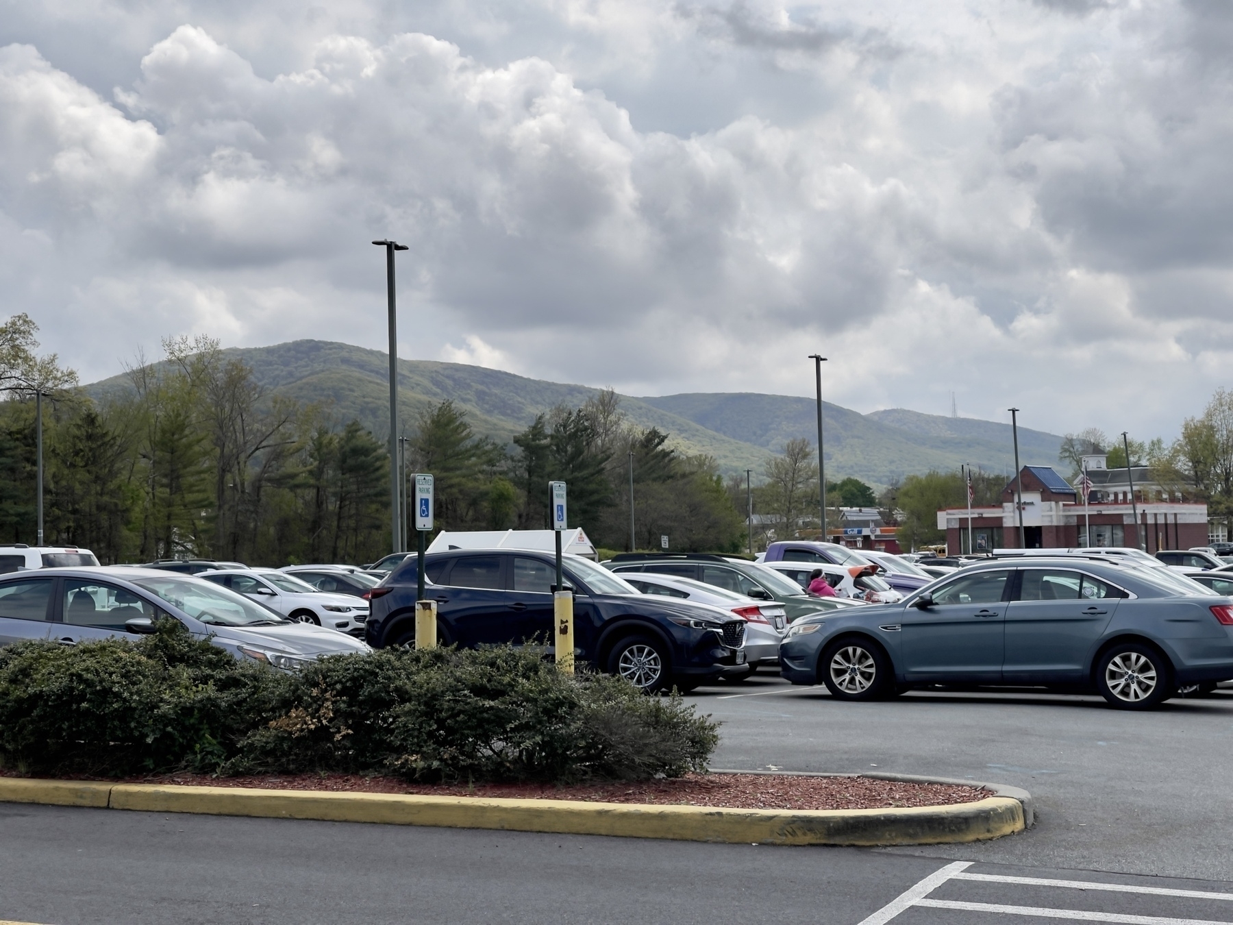 Chain of rounded mountains with parking lot in foreground. Color.