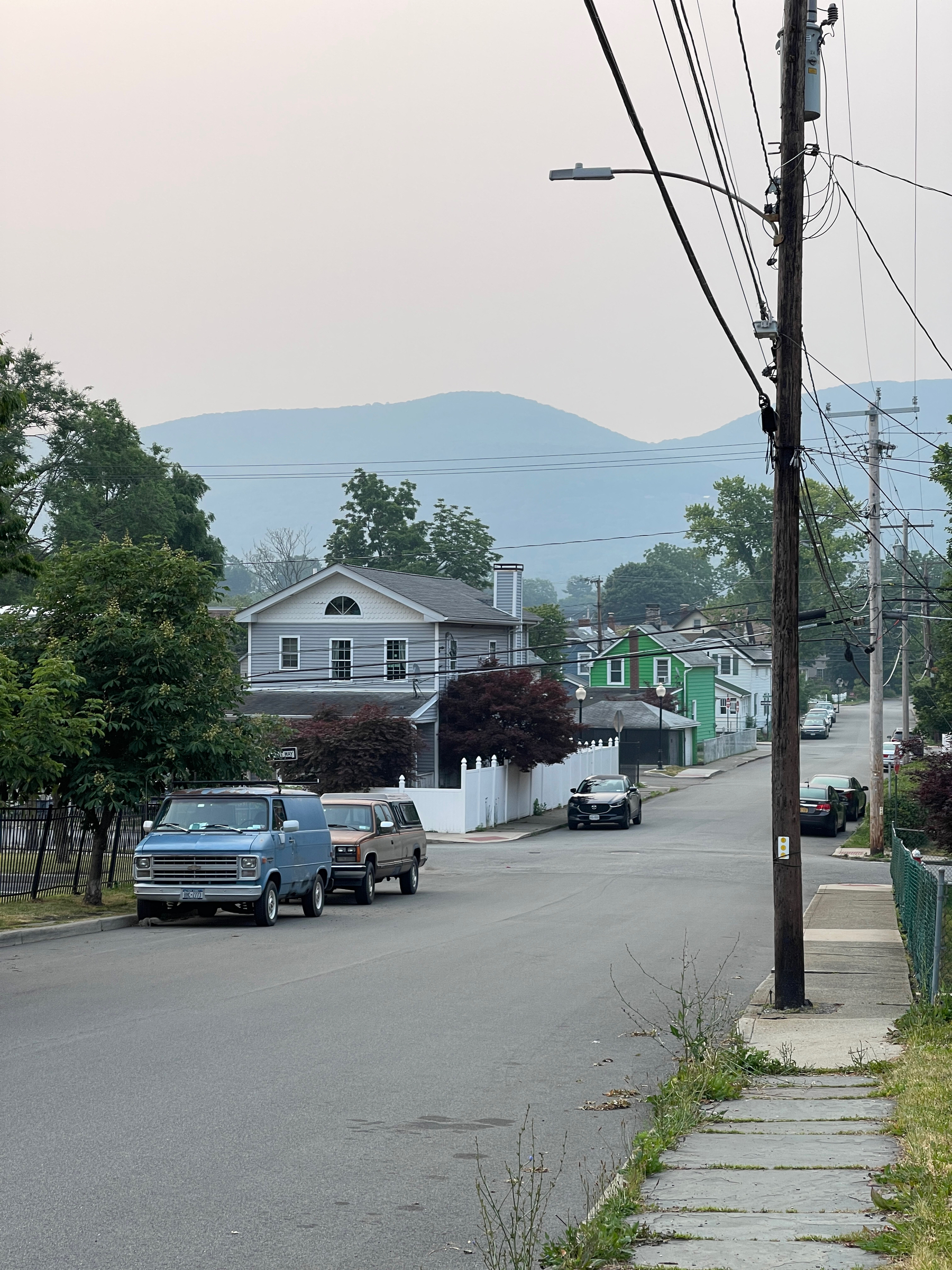 View down the street in Beacon, NY, mountains partially obscured by wildfire smoke.