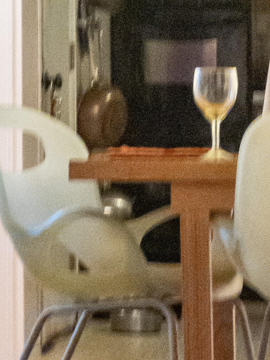 Closeup of table, chair and wine goblet from the previous image.