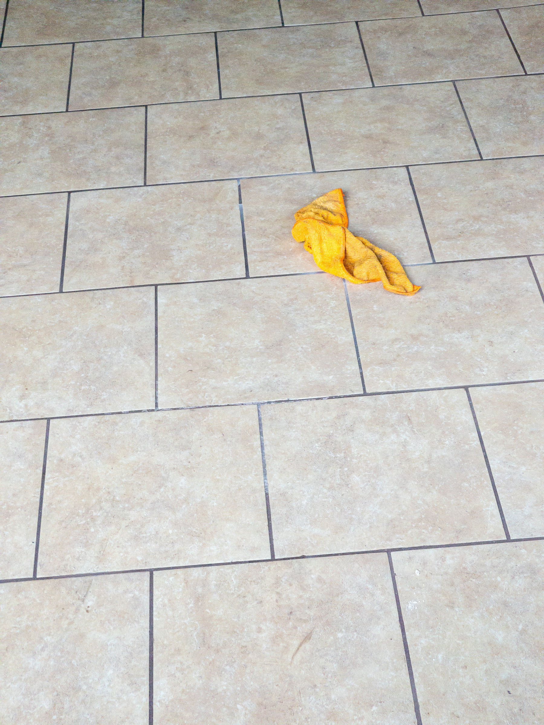 Yellow-orange rag on a tile floor.