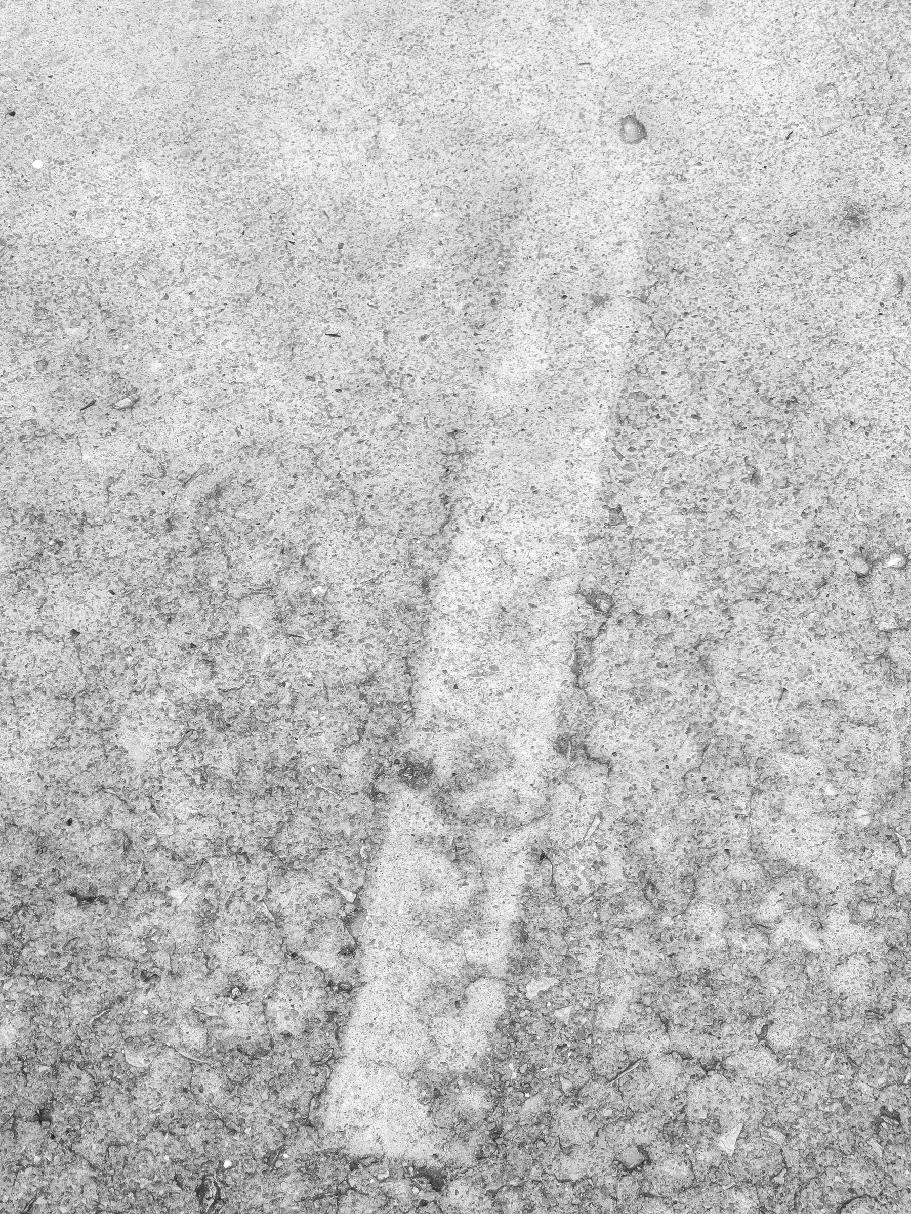Ghost outline of a board on the sidewalk running at a slight angle from bottom to top.