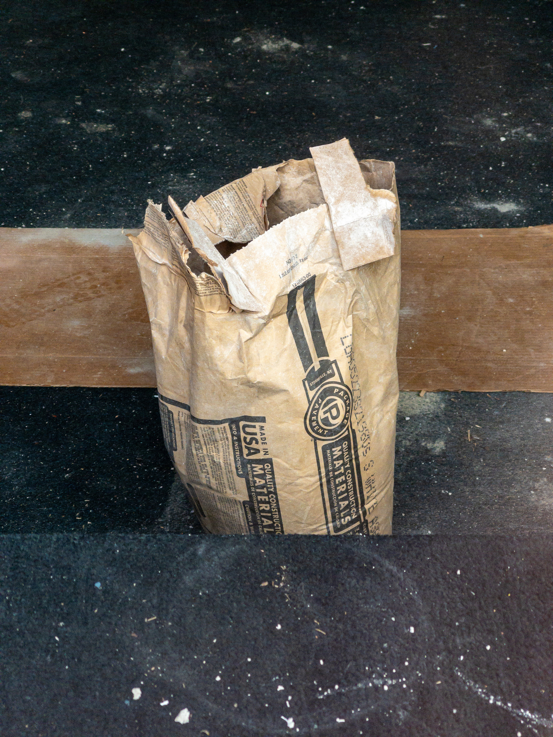 Bag of construction material standing on the floor of a shop being renovated.