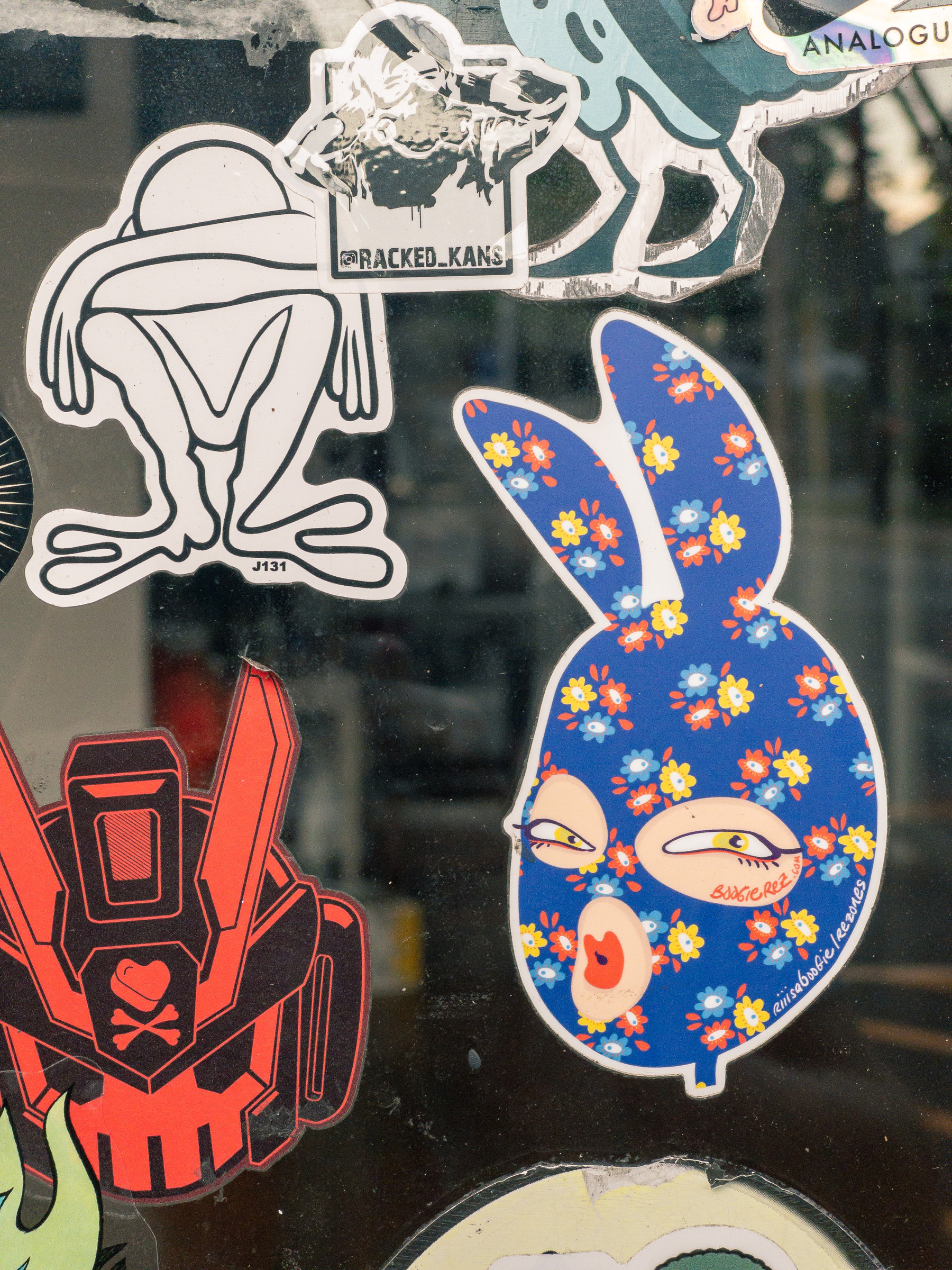 stickers on a window, the main subject a feminine sticker in the shape of a rabbit head
