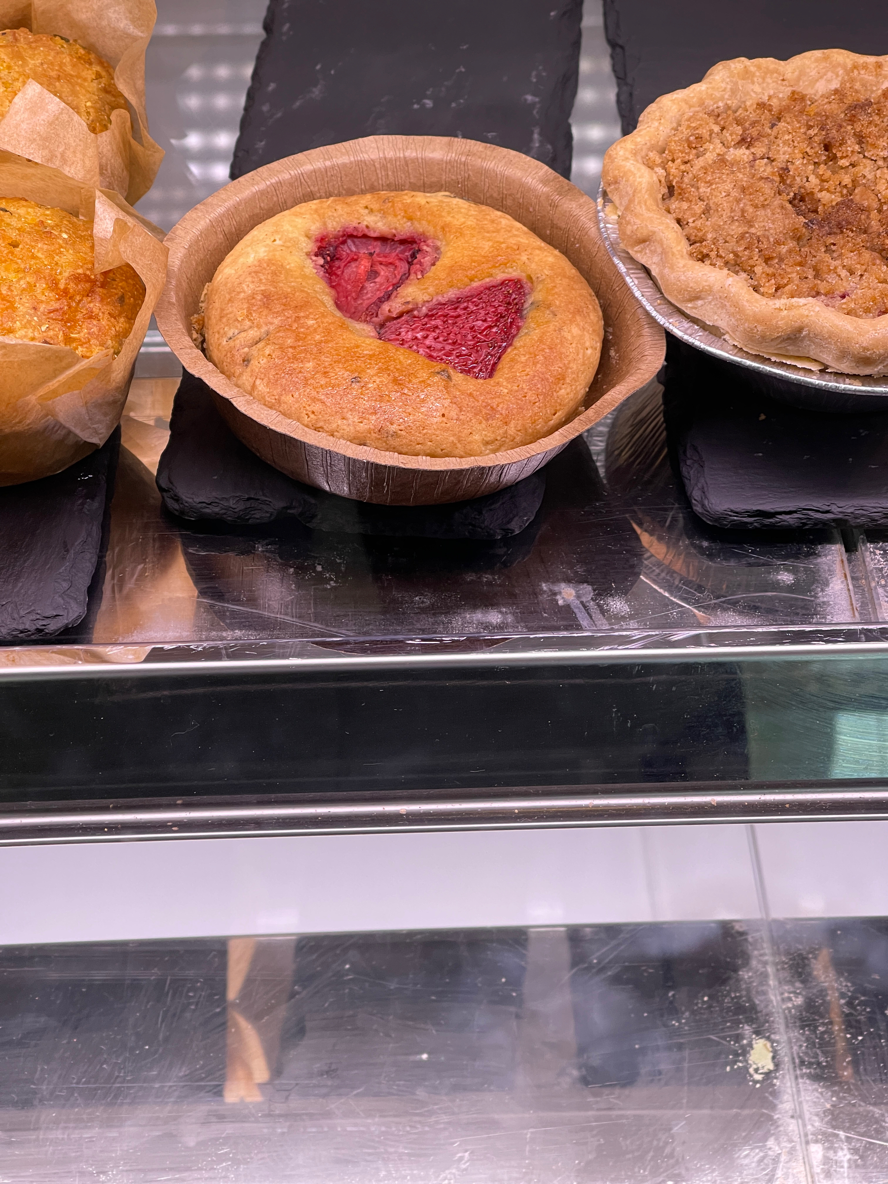 Strawberries imbedded in pastry on a display shelf.