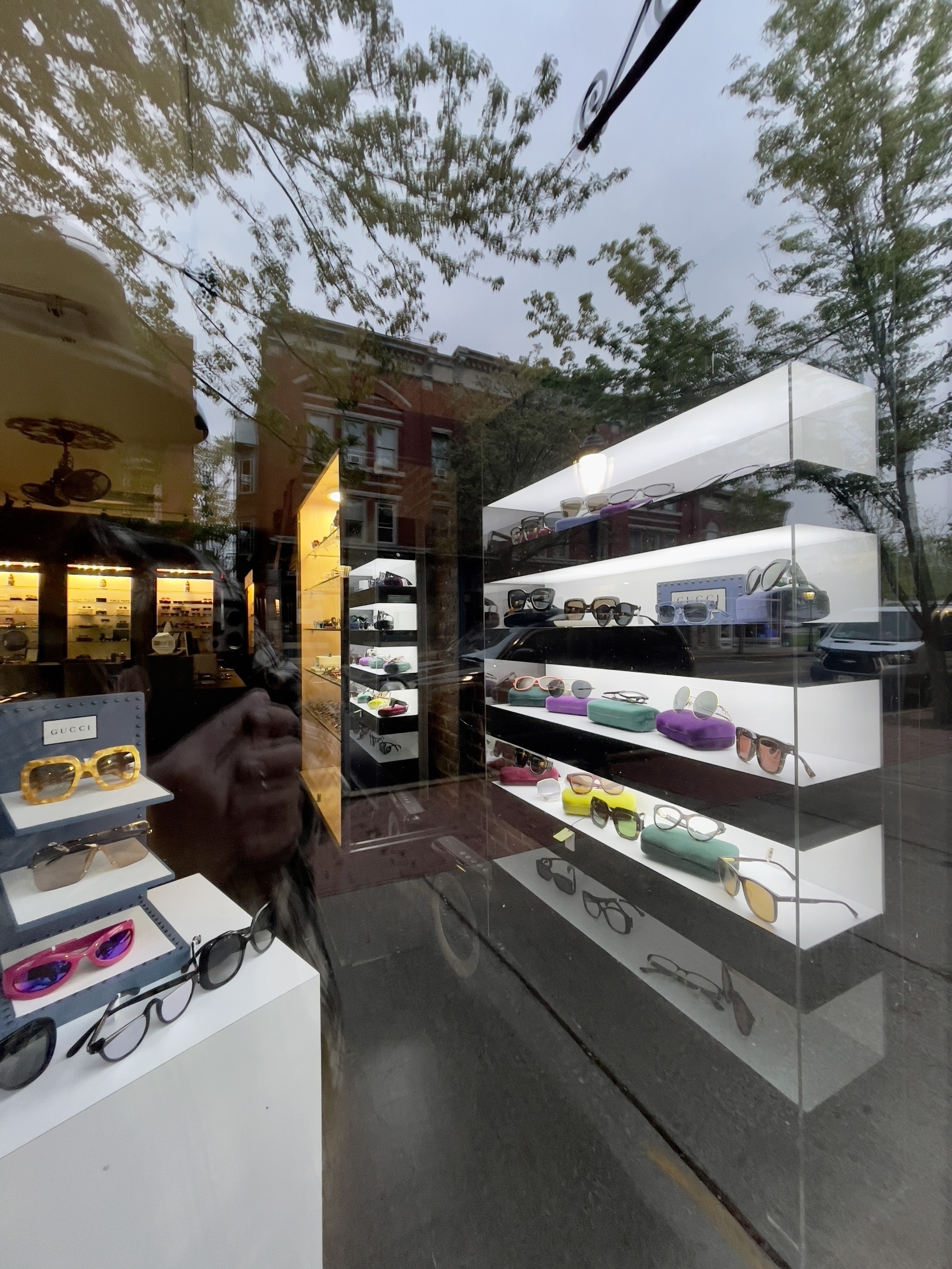 Opticians display cases with buildings reflected in the window.